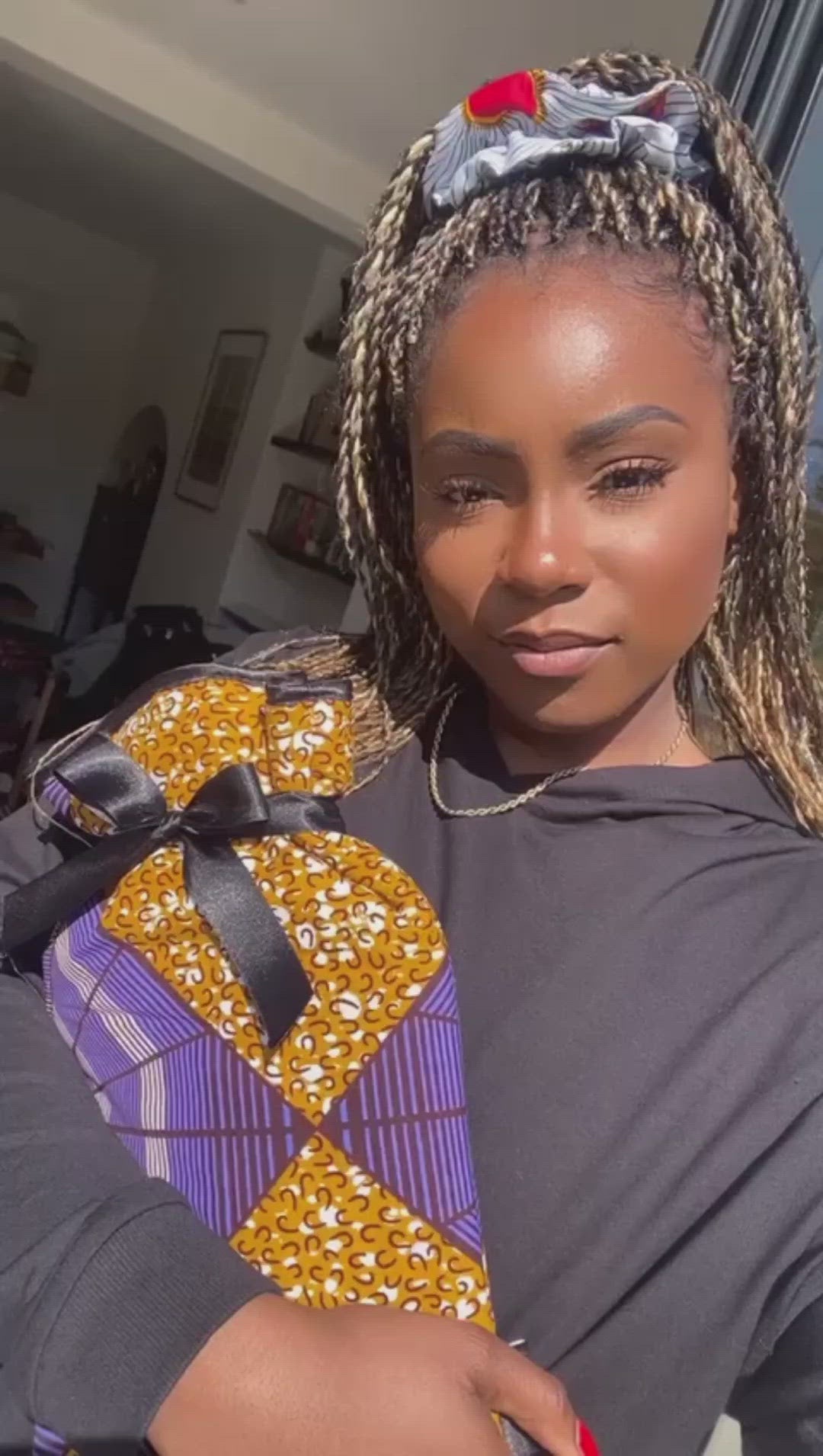 black woman holding lolly & kiks purple gold african print hot water bottle