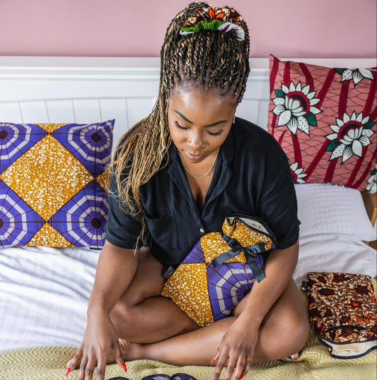 african print bedroom. Black woman with african wax print hot water bottles and cushions