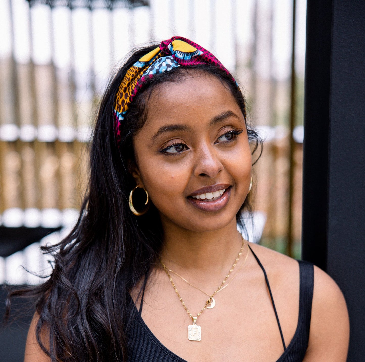 Model wears pink multicoloured headband in Bimpe print by Lolly and Kiks