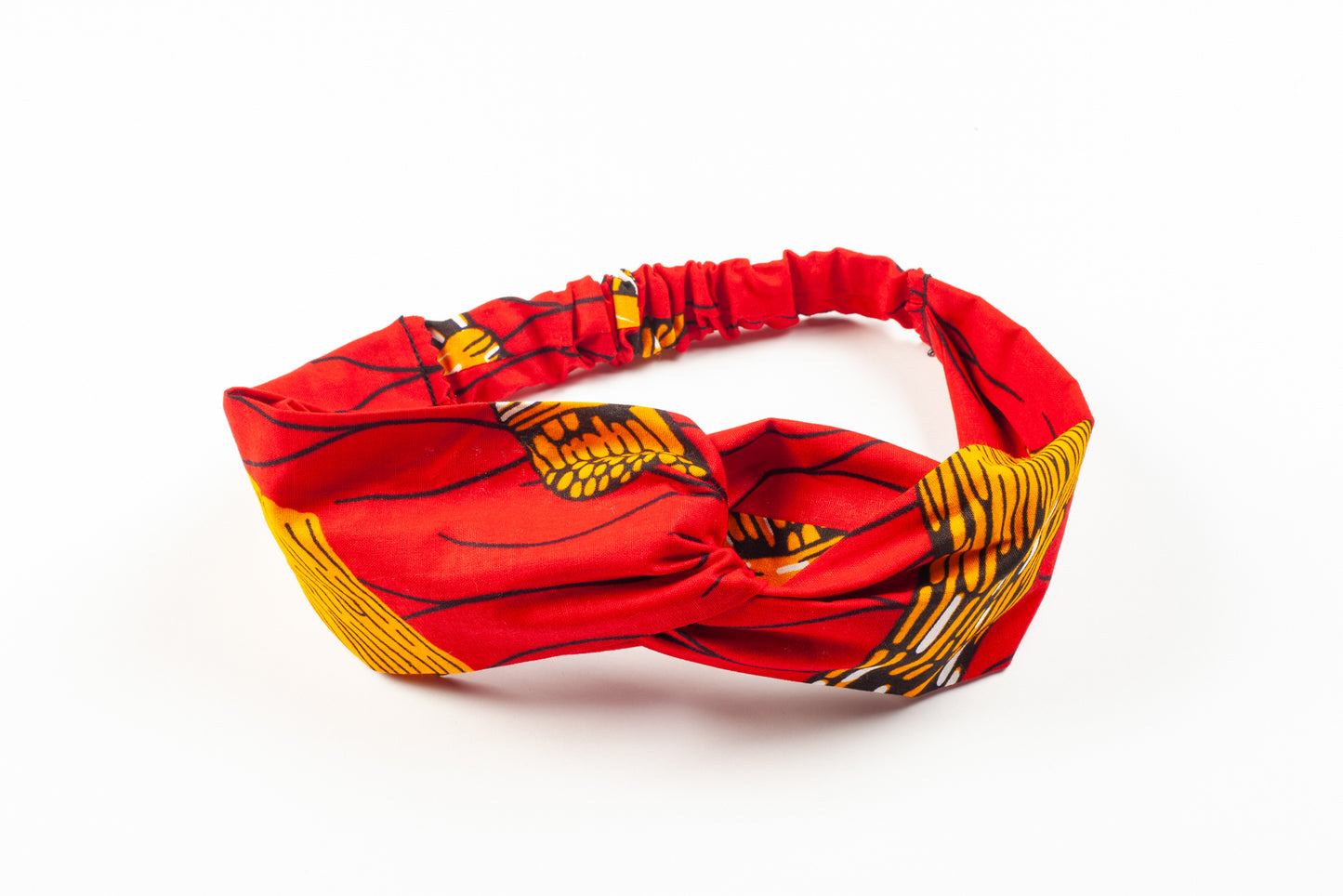 Red Igbale headband by Lolly and Kiks on a white surface