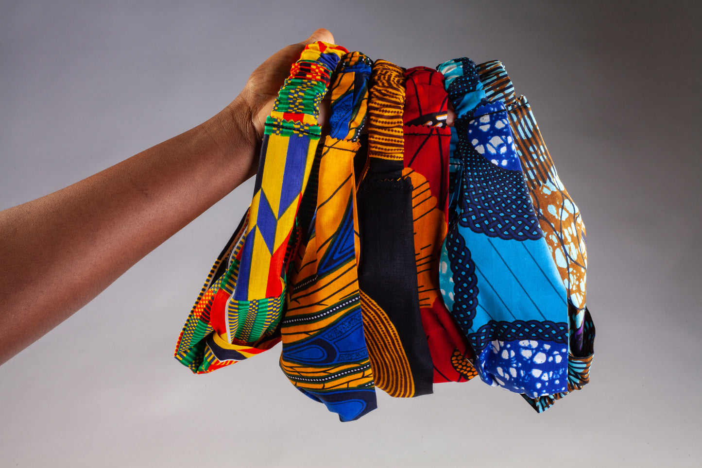 Model holds up range of Lolly and Kiks headbands in a variety of prints